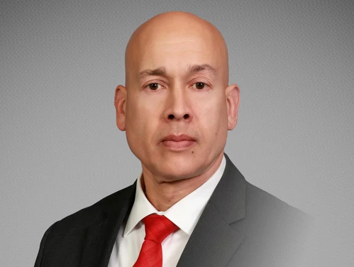 A headshot of Mark Foreman in front of a gray background