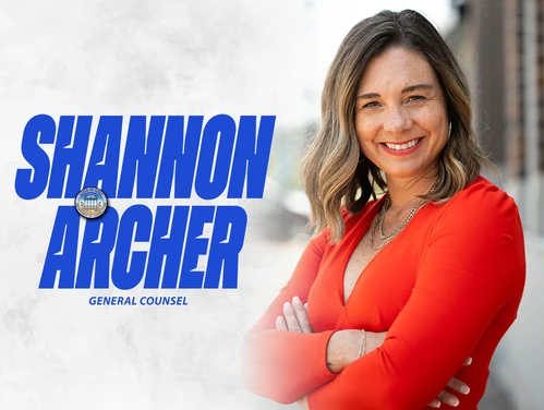Shannon Archer in front of a gray background with her name in bold blue font