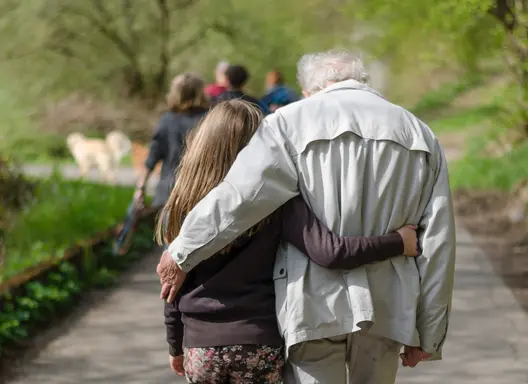 Grandfather hugging grandchild, seen from behind