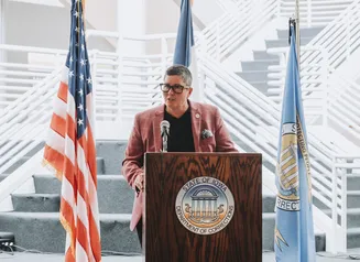 Director Skinner standing at the podium