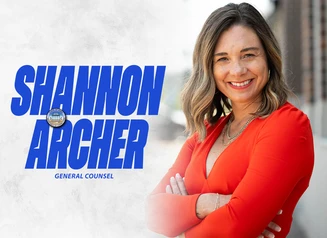 Shannon Archer in front of a gray background with her name in bold blue font
